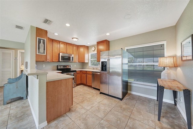 3171 Highlands Rd, Punta Gorda, FL 33983 - kitchen with appliances with stainless steel finishes, a peninsula, light countertops, recessed lighting, and light tile patterned flooring