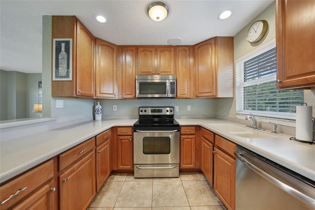 3171 Highlands Rd, Punta Gorda, FL 33983 - kitchen featuring appliances with stainless steel finishes, light countertops, light tile patterned floors, brown cabinetry, and recessed lighting