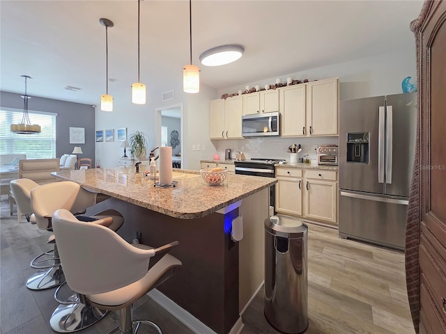 7292 Mikasa Dr, Punta Gorda, FL 33950 - kitchen with stainless steel appliances, a kitchen breakfast bar, a sink, a center island, and light stone counters