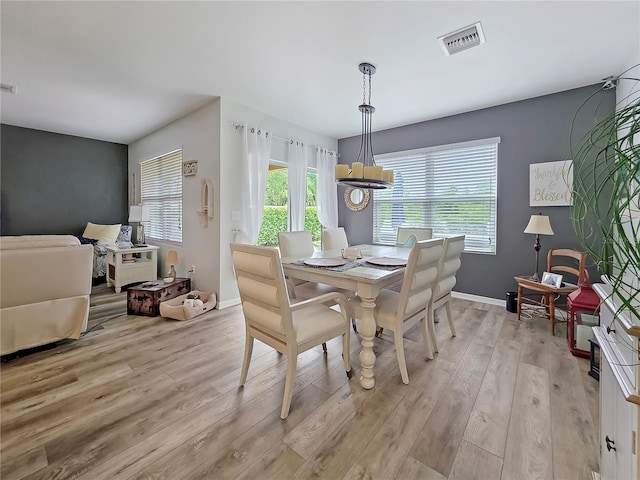 7292 Mikasa Dr, Punta Gorda, FL 33950 - dining area with light wood finished floors, a chandelier, and baseboards