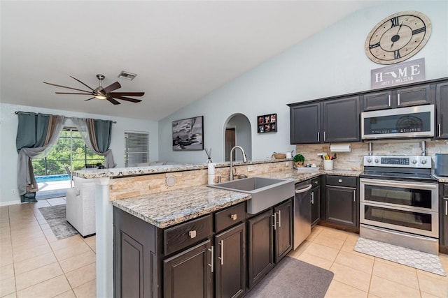 1444 Frisco Ter, Port Charlotte, FL 33953 - kitchen with stainless steel appliances, a sink, lofted ceiling, a peninsula, and light tile patterned flooring