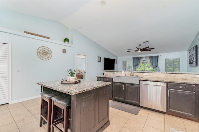 1444 Frisco Ter, Port Charlotte, FL 33953 - kitchen featuring stainless steel dishwasher, a sink, a kitchen island, light tile patterned flooring, and vaulted ceiling