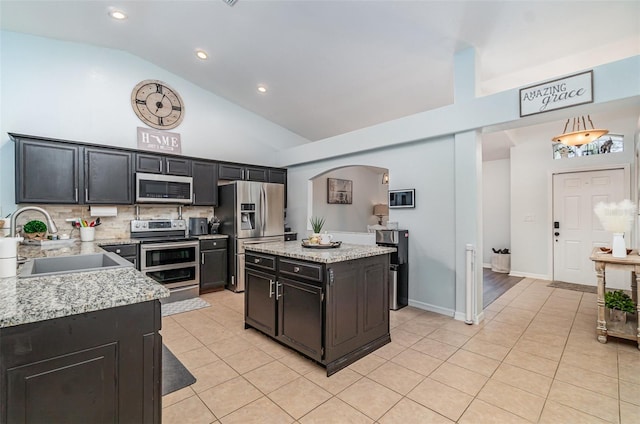 1444 Frisco Ter, Port Charlotte, FL 33953 - kitchen featuring stainless steel appliances, light tile patterned floors, a sink, high vaulted ceiling, and tasteful backsplash