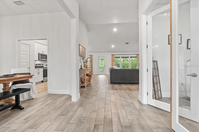 5436 Jessamine Ave, North Port, FL 34291 - hallway featuring light wood-type flooring, baseboards, recessed lighting, and vaulted ceiling
