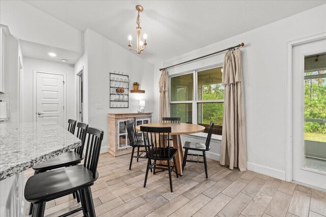 5436 Jessamine Ave, North Port, FL 34291 - dining room featuring light wood-style floors, a chandelier, baseboards, a fireplace, and recessed lighting