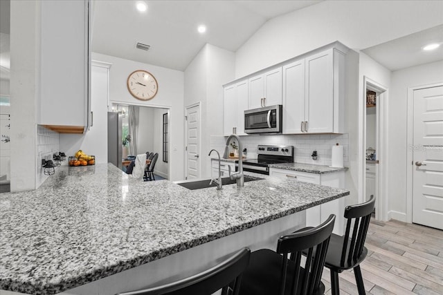 5436 Jessamine Ave, North Port, FL 34291 - kitchen with stainless steel appliances, a sink, a peninsula, decorative backsplash, and light stone countertops