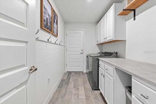 5436 Jessamine Ave, North Port, FL 34291 - washroom with separate washer and dryer, light wood finished floors, and cabinet space
