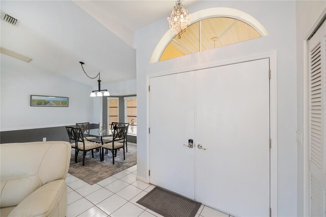 1 Sportsman Cir, Rotonda West, FL 33947 - entryway featuring a chandelier, lofted ceiling, light tile patterned flooring, and light colored carpet