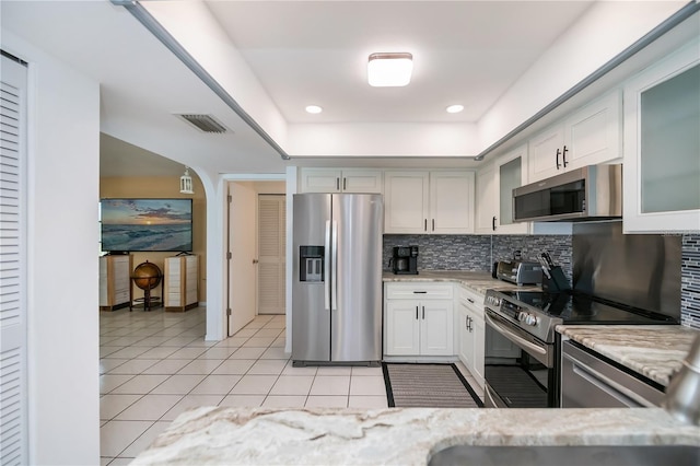 1 Sportsman Cir, Rotonda West, FL 33947 - kitchen featuring appliances with stainless steel finishes, light tile patterned floors, backsplash, glass insert cabinets, and recessed lighting