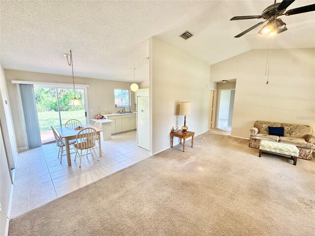 18335 Oxford Ave, Port Charlotte, FL 33948 - living area with light carpet, a ceiling fan, light tile patterned flooring, a textured ceiling, and lofted ceiling