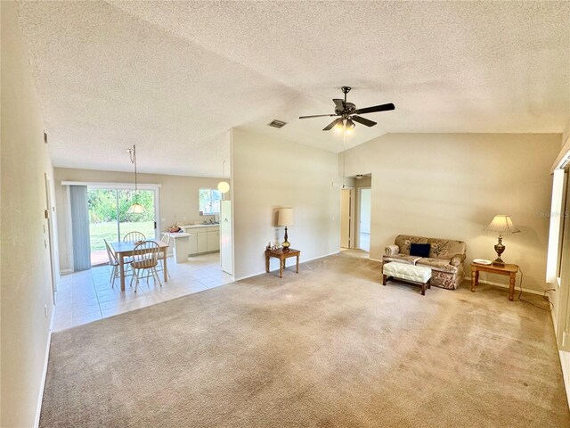 18335 Oxford Ave, Port Charlotte, FL 33948 - living area with light colored carpet, ceiling fan, a textured ceiling, vaulted ceiling, and baseboards