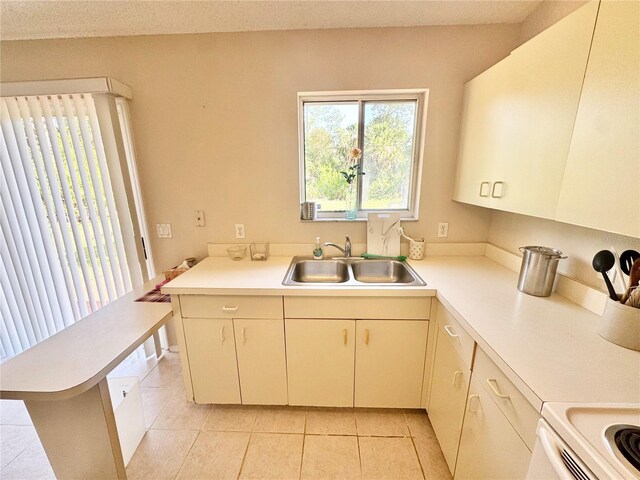 18335 Oxford Ave, Port Charlotte, FL 33948 - kitchen with a sink, light countertops, light tile patterned flooring, and cream cabinets