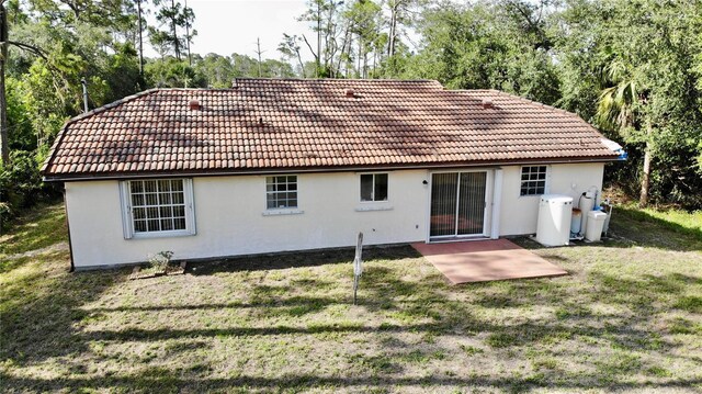18335 Oxford Ave, Port Charlotte, FL 33948 - rear view of property with a tile roof, stucco siding, and a yard