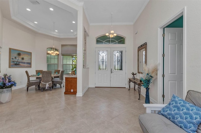 1499 Nuremberg Blvd, Punta Gorda, FL 33983 - entryway with a chandelier, ornamental molding, a high ceiling, baseboards, and light tile patterned flooring