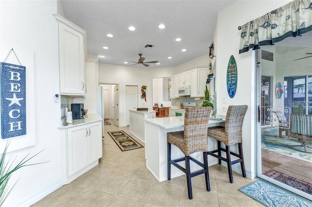 1499 Nuremberg Blvd, Punta Gorda, FL 33983 - kitchen with white appliances, a ceiling fan, a peninsula, white cabinetry, and recessed lighting