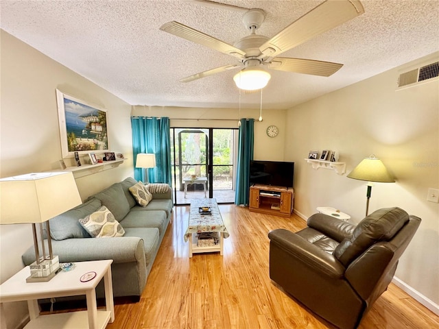 1515 Forrest Nelson Blvd Unit D102, Port Charlotte, FL 33952 - living area featuring a textured ceiling, light wood-style floors, ceiling fan, and baseboards