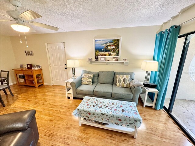 1515 Forrest Nelson Blvd Unit D102, Port Charlotte, FL 33952 - living area featuring wood finished floors, a textured ceiling, a ceiling fan, and plenty of natural light