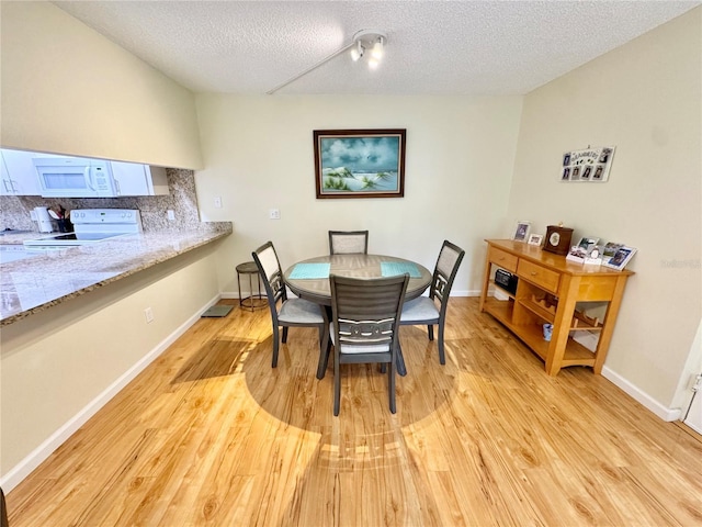 1515 Forrest Nelson Blvd Unit D102, Port Charlotte, FL 33952 - dining area featuring light wood-type flooring, a textured ceiling, and baseboards