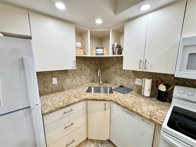 1515 Forrest Nelson Blvd Unit D102, Port Charlotte, FL 33952 - kitchen with white appliances, a sink, white cabinets, decorative backsplash, and recessed lighting