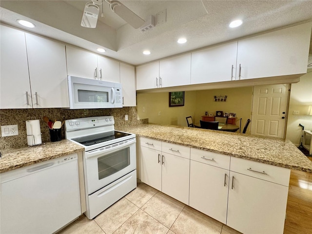 1515 Forrest Nelson Blvd Unit D102, Port Charlotte, FL 33952 - kitchen featuring white appliances, white cabinets, recessed lighting, backsplash, and light stone countertops