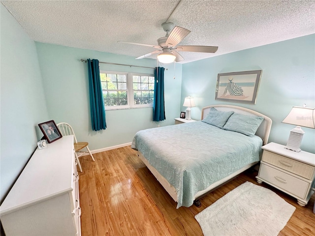 1515 Forrest Nelson Blvd Unit D102, Port Charlotte, FL 33952 - bedroom featuring a textured ceiling, light wood-type flooring, a ceiling fan, and baseboards