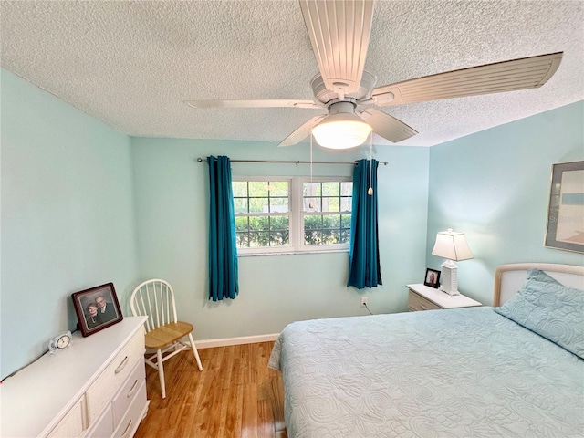 1515 Forrest Nelson Blvd Unit D102, Port Charlotte, FL 33952 - bedroom featuring a textured ceiling, light wood-type flooring, baseboards, and a ceiling fan