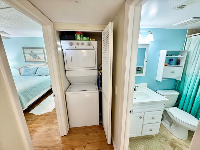 1515 Forrest Nelson Blvd Unit D102, Port Charlotte, FL 33952 - washroom featuring stacked washer / dryer and light wood-style flooring