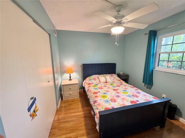 1515 Forrest Nelson Blvd Unit D102, Port Charlotte, FL 33952 - bedroom with a textured ceiling, wood finished floors, ceiling fan, baseboards, and a closet