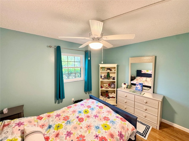 1515 Forrest Nelson Blvd Unit D102, Port Charlotte, FL 33952 - bedroom with wood finished floors, a textured ceiling, a ceiling fan, and baseboards
