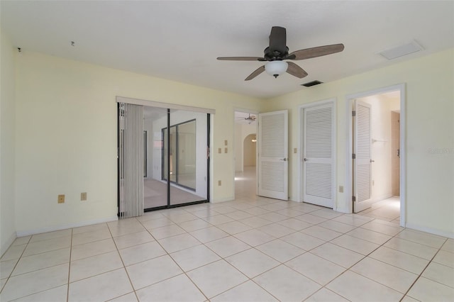 1472 Oriel Ct, Punta Gorda, FL 33983 - unfurnished bedroom featuring access to outside, arched walkways, a ceiling fan, baseboards, and light tile patterned floors