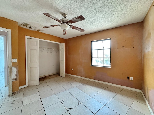 1611 Robbins Rd, Nokomis, FL 34275 - unfurnished bedroom featuring a closet, light tile patterned floors, a textured ceiling, ceiling fan, and baseboards