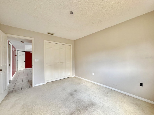 1611 Robbins Rd, Nokomis, FL 34275 - unfurnished bedroom with carpet flooring, a textured ceiling, baseboards, and a closet
