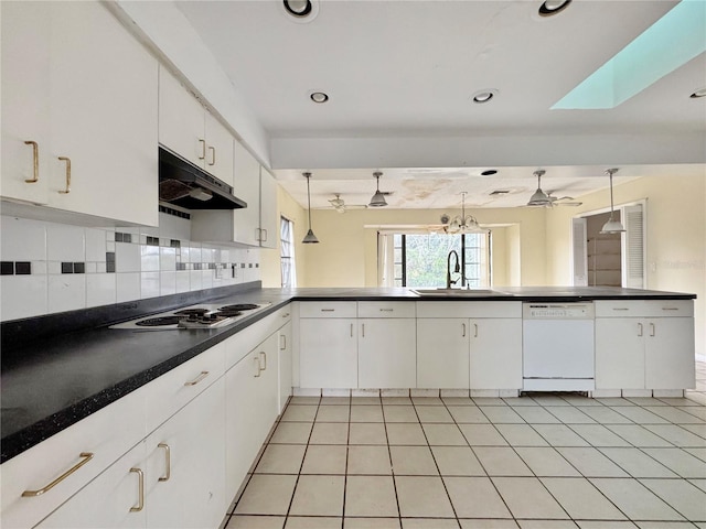 1611 Robbins Rd, Nokomis, FL 34275 - kitchen featuring white dishwasher, a sink, under cabinet range hood, dark countertops, and electric stovetop