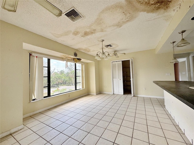 1611 Robbins Rd, Nokomis, FL 34275 - empty room with a textured ceiling, light tile patterned floors, baseboards, and a chandelier