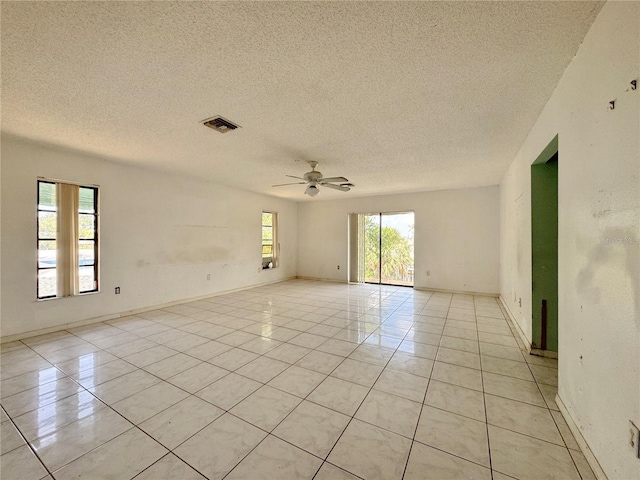 1611 Robbins Rd, Nokomis, FL 34275 - empty room featuring a textured ceiling, light tile patterned floors, ceiling fan, and baseboards