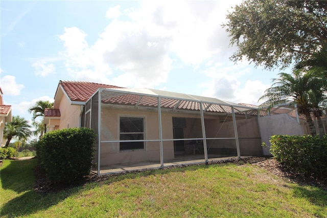 3803 Albacete Cir Unit 64, Punta Gorda, FL 33950 - back of house featuring stucco siding, a tiled roof, a yard, a patio, and glass enclosure