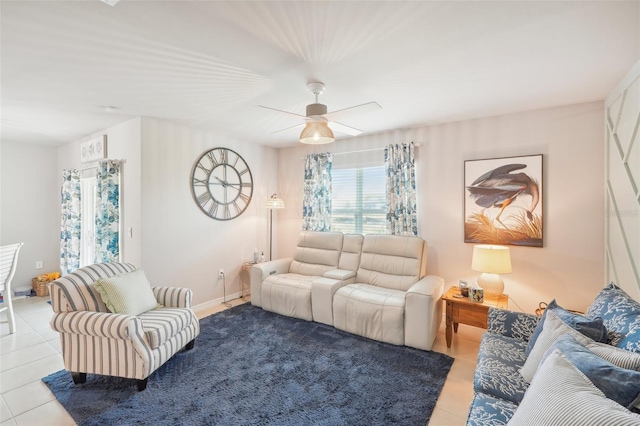 tiled living area with ceiling fan and baseboards