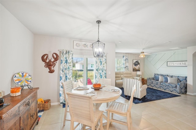 dining area with light tile patterned floors, a chandelier, baseboards, and a ceiling fan
