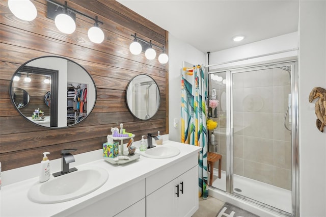full bath featuring a stall shower, double vanity, and tile patterned floors