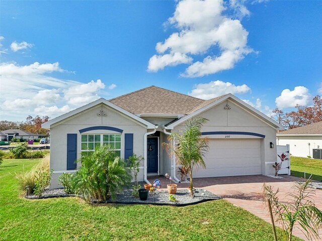 ranch-style home featuring a garage, a front yard, stucco siding, decorative driveway, and cooling unit