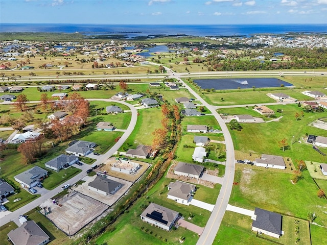 aerial view of property's location featuring a large body of water and nearby suburban area