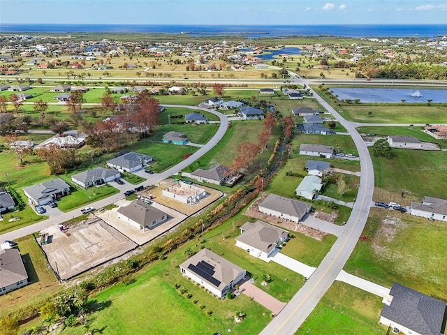 aerial view of property and surrounding area with a nearby body of water and nearby suburban area