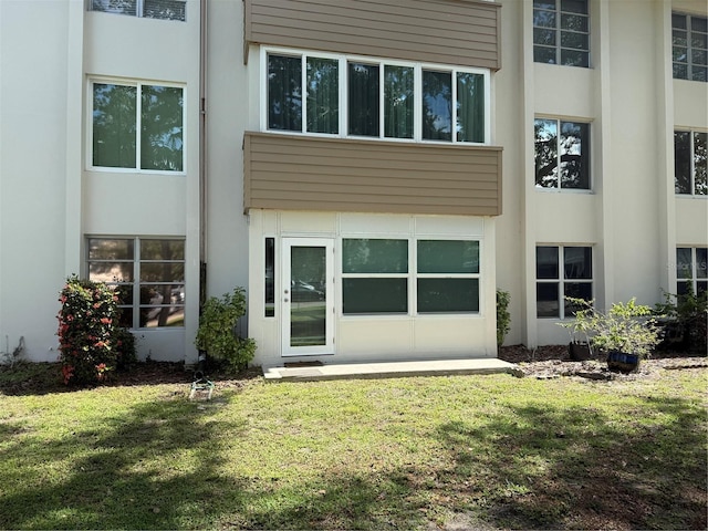 21260 Brinson Ave Unit 110, Port Charlotte, FL 33952 - back of property featuring stucco siding and a yard