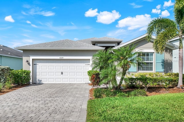 43249 Treadway Dr, Punta Gorda, FL 33982 - view of front facade with decorative driveway, a garage, and stucco siding