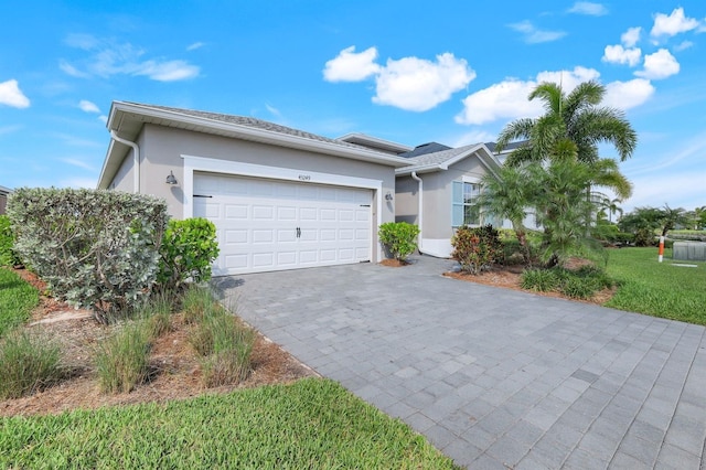 43249 Treadway Dr, Punta Gorda, FL 33982 - single story home featuring stucco siding, decorative driveway, a garage, and a front lawn