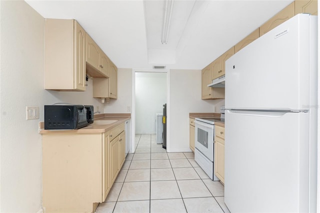 22481 Westchester Blvd Unit B47, Punta Gorda, FL 33980 - kitchen with white appliances, under cabinet range hood, light countertops, cream cabinetry, and light tile patterned floors