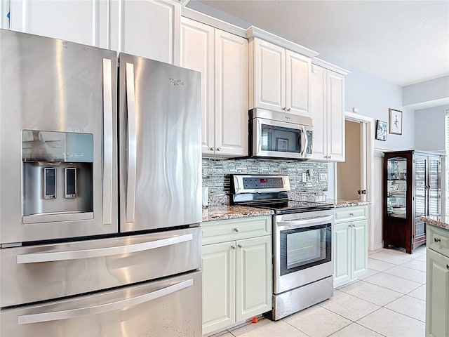 1007 Comstock St, Port Charlotte, FL 33952 - kitchen with appliances with stainless steel finishes, backsplash, light tile patterned flooring, and light stone counters