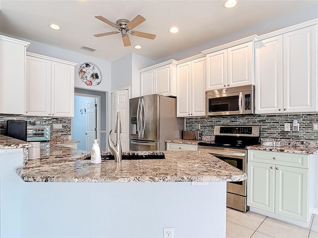 1007 Comstock St, Port Charlotte, FL 33952 - kitchen with stainless steel appliances, ceiling fan, light stone counters, and recessed lighting