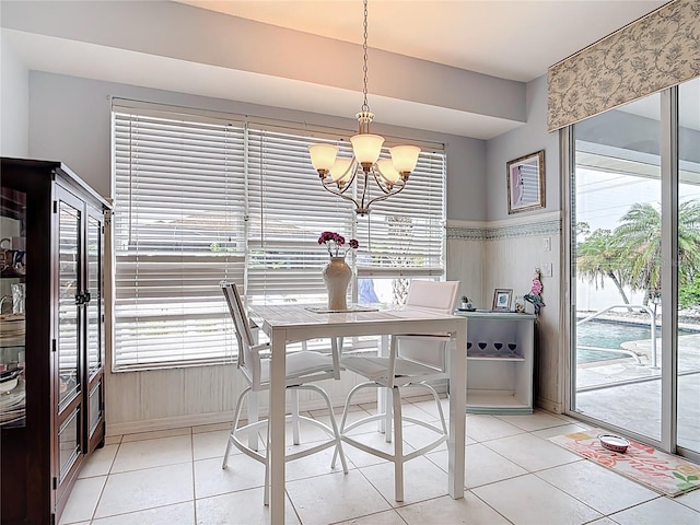 1007 Comstock St, Port Charlotte, FL 33952 - dining area with a chandelier, light tile patterned floors, and a wainscoted wall