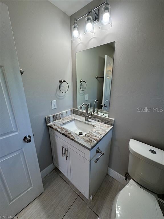 4916/4918 24th St SW, Lehigh Acres, FL 33973 - half bath featuring vanity, wood finished floors, toilet, and baseboards